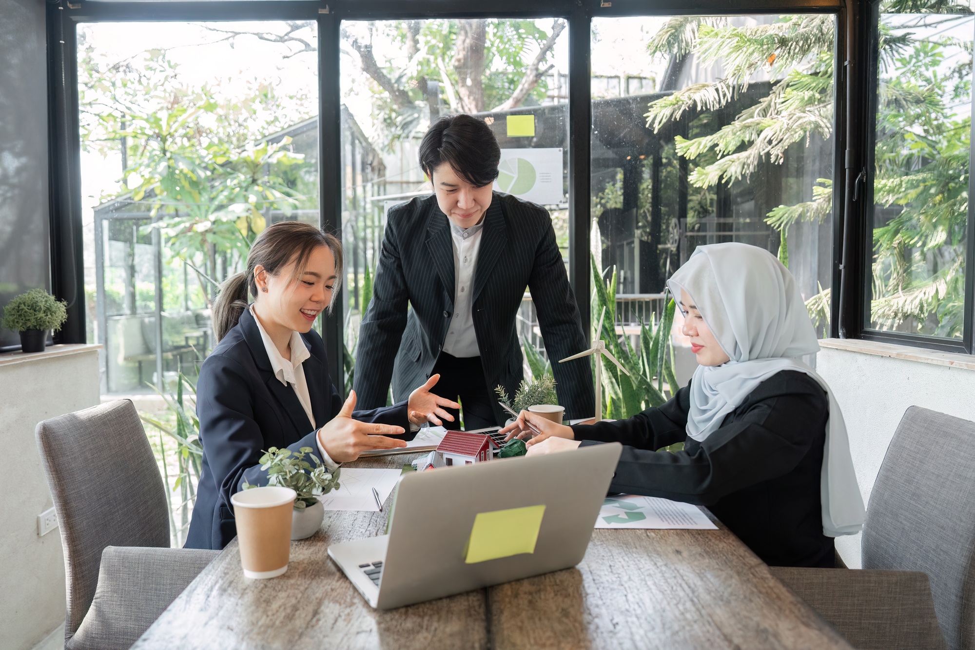 A diverse team discussing sustainable strategies in an eco-friendly workspace.
