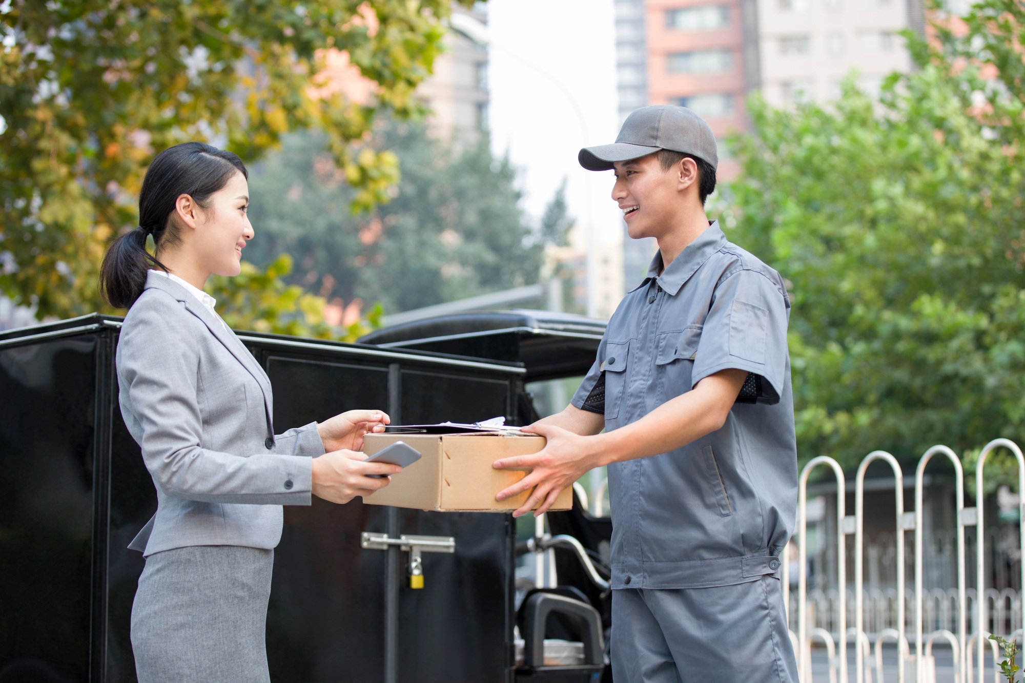Young woman getting a package from delivery person